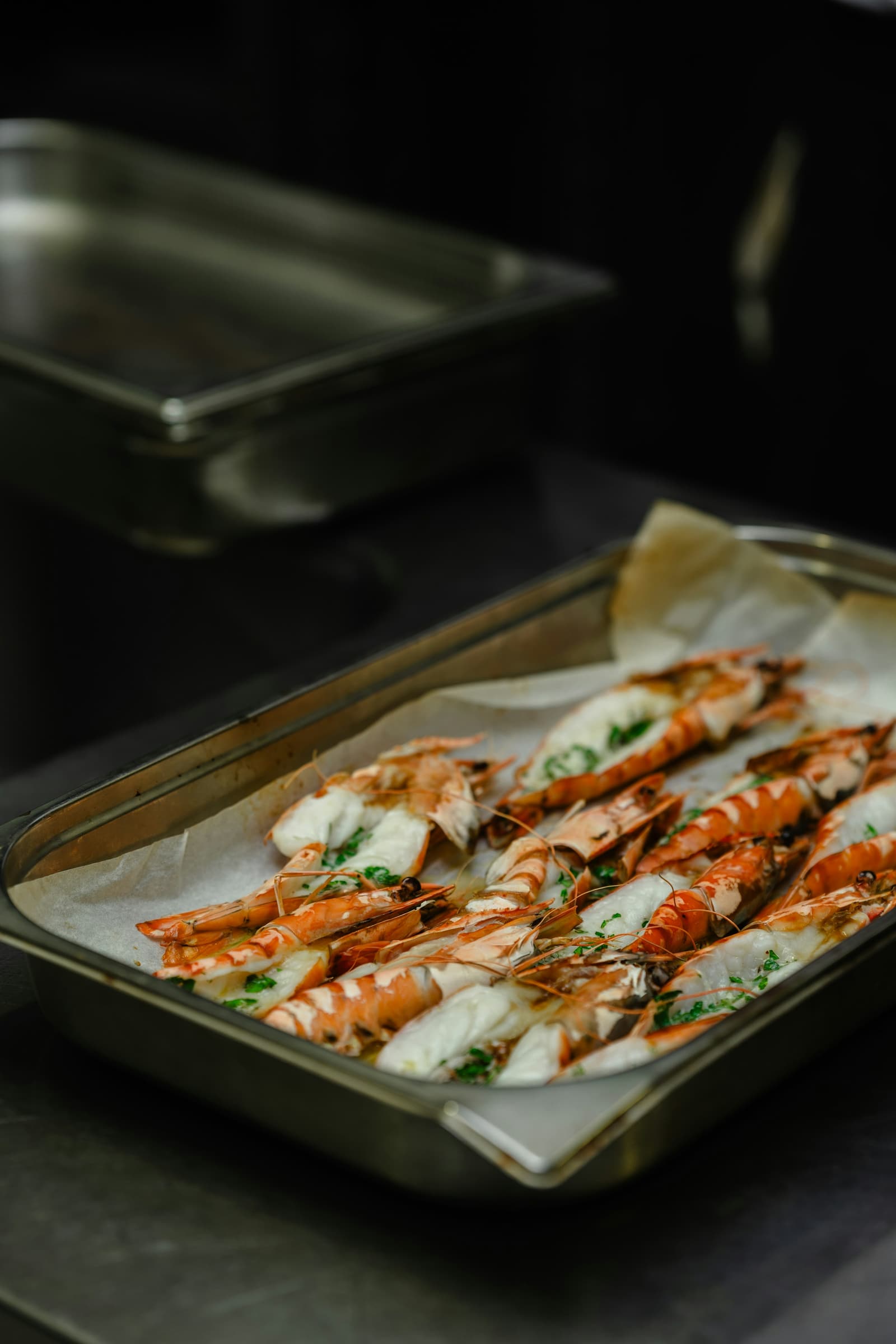 Head-on shrimp roasted on a sheet pan in a professional kitchen